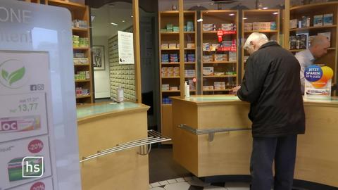 Ein älterer Mann kauft in der Apotheke Medikamente