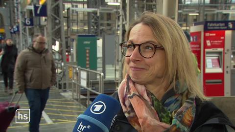 Am Bahnhof wird eine blonde Frau mit Brille interviewt