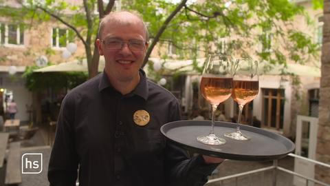 Kai Beuscher aus Fritzlar hält ein Tablett mit zwei gefüllten Weingläsern darauf.