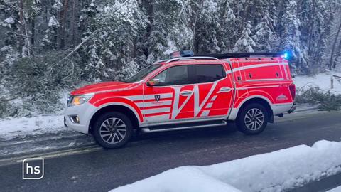 Feuerwehrauto steht mikt Blaulicht auf schneebedeckter Fahrbahn.