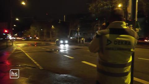 Polizist misst Geschwindigkeit eines herannahenden Autos auf einer dunklen Straße.