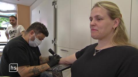 Frau beim Tattoowierer