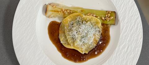 Ochsenschwanz-Raviolo auf Orangen-Rindfleisch-Jus an geschmortem Lauch mit Pinienkern-Vinaigrette