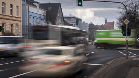 Taxi, LKW und Bus im fließenden Verkehr an einer Kreuzung (aufgenommen mit Langzeitbelichtung).