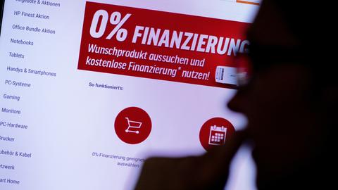 Eine Frau schaut sich auf einer Website für Technik-Produkte die Werbung für eine Null-Prozent-Finanzierung an.