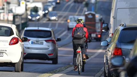 Ein Fahrradfahrer fährt auf einer stark befahrenen Straße.