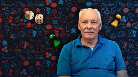 Mann steht vor einem Brettspiel.
