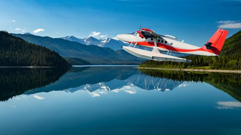 Ein Wasserflugzeug fliegt über einen See.