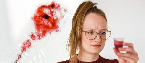 Eine junge Frau hält eine gefüllte Menstruationstasse in der Hand und schaut sie skeptisch an. Im Hintergrund sieht man in Wasser aufgelöstes Blut im Abfluss verschwinden (Collage).