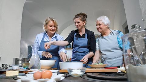 Äbtissin Kristin Püttmann (l.) und Annette Behnken (M.) bereiten in der Küche von Kloster Medingen Spinatklöße zu.