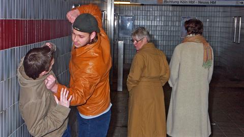 Wegschauen statt Zivilcourage: Zwei Passanten schauen weg, während ein Jugendlicher in einer U-Bahnstation einen anderen verprügelt. (Gestellte Aufnahme.)