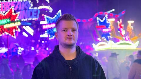 Reporter Simon Rustler steht vor dem Breakdancer auf dem Hochheimer Markt. 