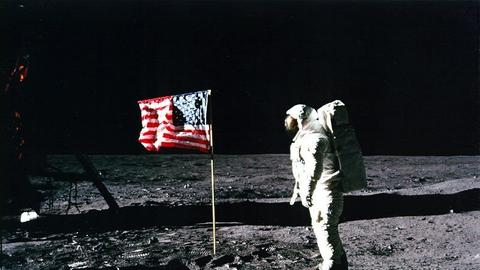 NASA-Originalaufnahme von Edwin Aldrin auf dem Mond neben einer amerikanischen Flagge. 