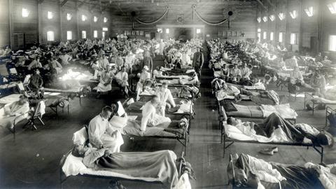 Patienten, die an der Spanischen Grippe erkrankt sind, liegen in Betten eines Notfallkrankenhauses im Camp Funston der Militärbasis Fort Riley in Kansas (USA) (Aufnahme von 1918).