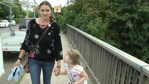 Natascha Hof spaziert mit ihrer Tochter über eine Brücke.