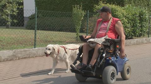 Holger Flauaus mit seinem Begleithund im Rollstuhl.