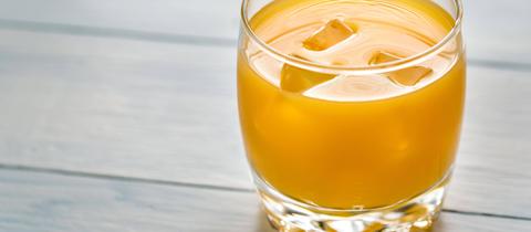 orangenes Getränk mit Eiswürfeln