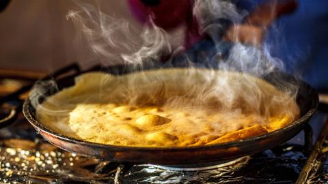 Crêpe wird in einer Pfanne gebraten