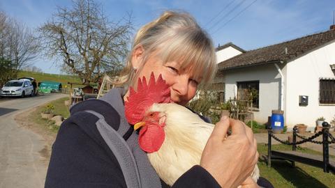 Corinna Ertl mit einem Hahn. 