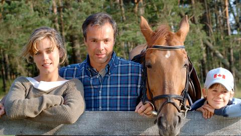 Pferdeflüsterer Nils Peterson, mit Tibor, Katja und ihrem Sohn Lukas hinter einem Gatter. 