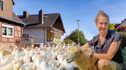 Bio-Bäuerin Franziska mit einem Schaf, dahinter Gänse.