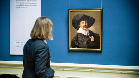 Eine Frau betrachtet das Kunstwerk "Brustbild eines unbekannten Herrn mit Hut" von Frans Hals. 