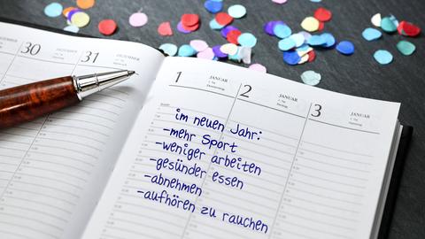 Eine im Kalender eingetragene Liste mit guten Vorsätzen für's neue Jahr: Mehr Sport, weniger arbeiten, gesünder essen, abnehmen und aufhören zu rauchen. 