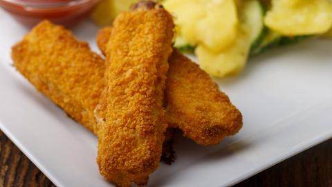Fischstäbchen mit Kartoffelsalat auf dem Teller 