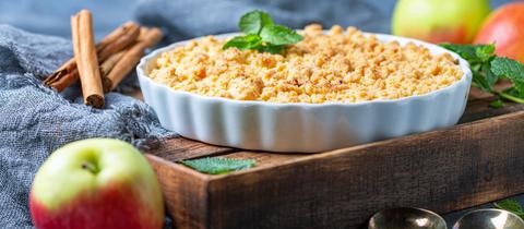 Apfel -Birnen-Crumble in einer weißen Keramikform
