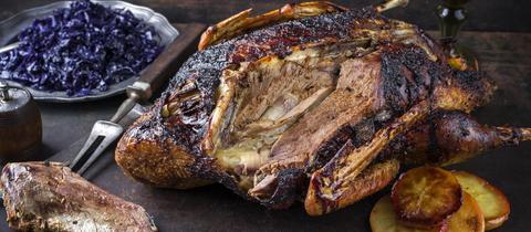 Gänsebraten mit Orangenscheiben und blauem Kraut auf altem Blech