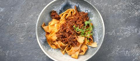 Traditionelles italienisches Ragu alla Bolognese-Sauce mit Papedelle-Nudeln und Parmesankäse.