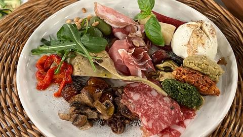 Antipasti-Teller mit Salami, Schinken, Zucchini, Champignons und Auberginen