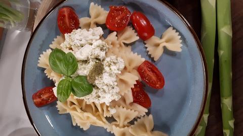 Farfallenudeln angerichtet mit Basilikum und Tomaten