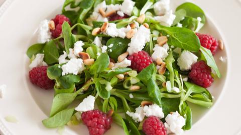 Ein Teller Feldsalat mit Fetakäse und Himbeeren
