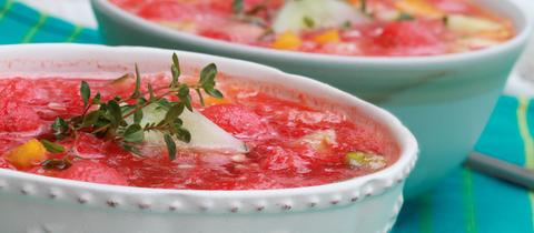 Wassermelonen-Gazpacho aus Wassermelone, gelber Paprika, Gurke und garniert mit einem Zweig frischen Thymian.