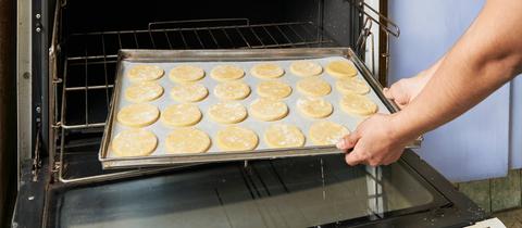 Kekse werden in einen Ofen geschoben. 