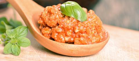 Ein Holzlöffel gefüllt mir Ragú. 