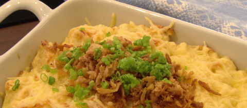 Käsespätzle in einer Auflaufform, darauf Röstzwiebeln und Petersilie.