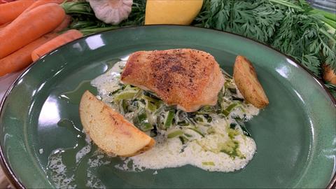 Goldforellenfilet und zwei Kartoffelschnitze auf feinem Lauchgemüse.
