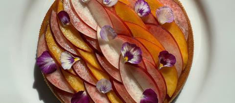 Eine Pfirsichtarte dekoriert mit Blüten. 
