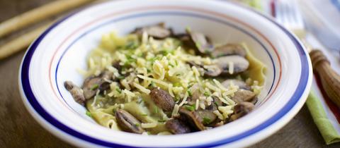Hausgemachte Grünkohl-Walnuss-Pesto-Ravioli mit Pilzen und veganem Käse und Schnittlauch