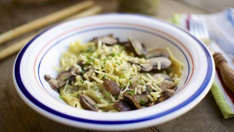 Hausgemachte Grünkohl-Walnuss-Pesto-Ravioli mit Pilzen und veganem Käse und Schnittlauch