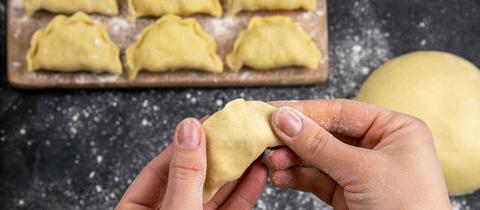 Eine gefaltete Ravioli liegt in der Hand