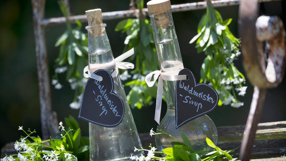 Zwei durchsichtige Glasflaschen Waldmeistersirup