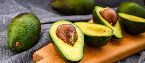Aufgeschnittene Avocados auf einem Brett. 