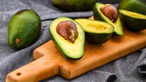 Aufgeschnittene Avocados auf einem Brett. 