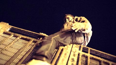 Imad, einer der gestrandeten Jungs, klettert über den Zaun, der den Hafen von der Stadt Melilla in Marokko trennt.