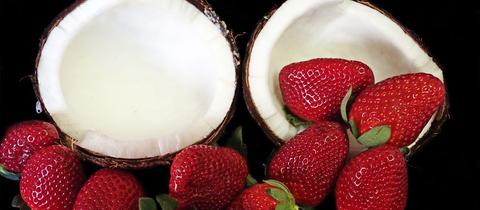 Erdbeeren und eine halbierte Kokosnuss.