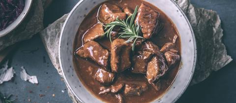 Gulasch vom Rind in einer großen Porzellanschüssel.