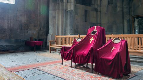 Ein Blick ins Kloster Haghpat, purpurfarbene Gewänder auf Stühlen. 